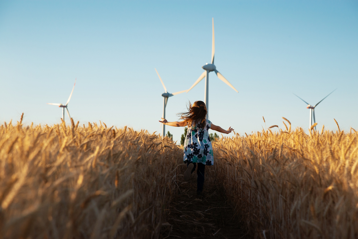 Niña corriendo por un campo de trigo