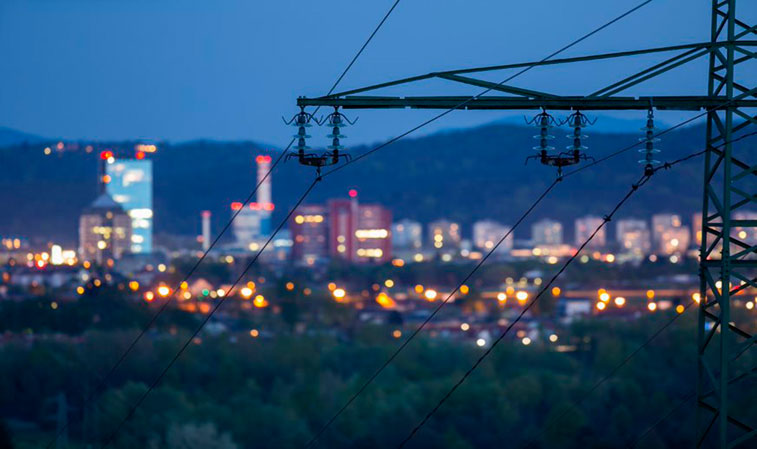 Torre eléctrica con ciudad de fondo