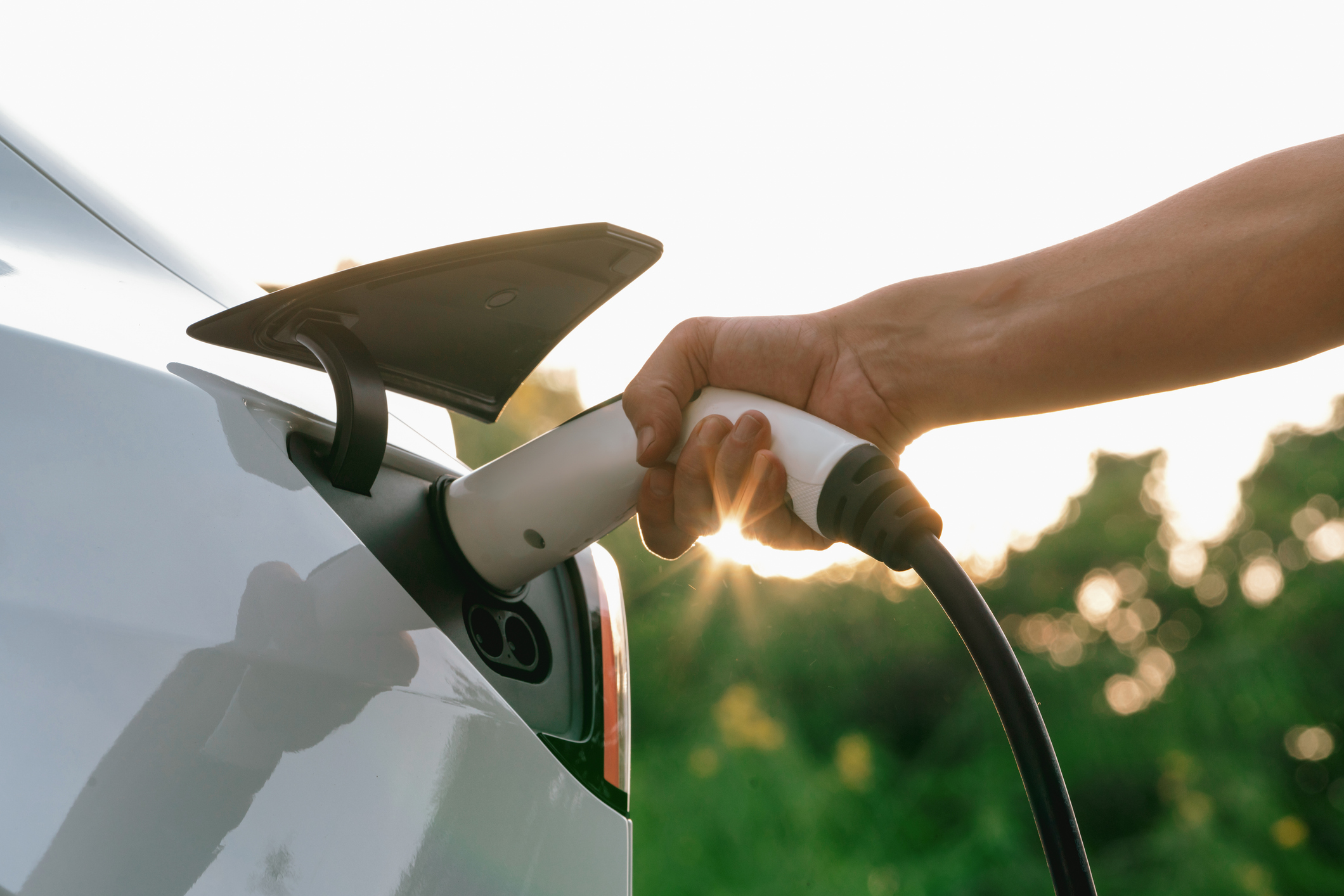 Persona cargando coche eléctrico