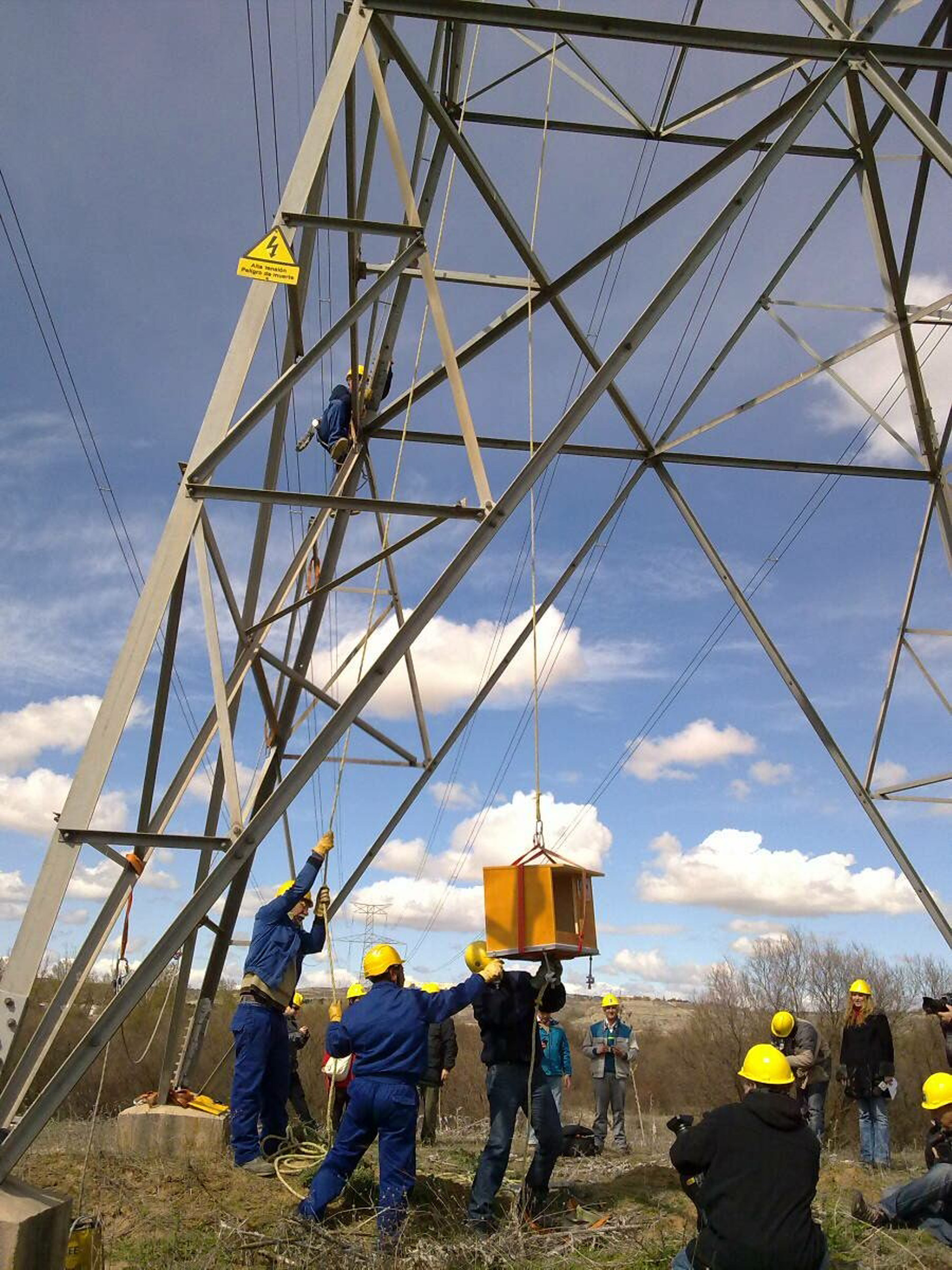 Trabajadores de Red Eléctrica instalando las cajas nido en uno de los apoyos en el parque regional del Sureste, Madrid.